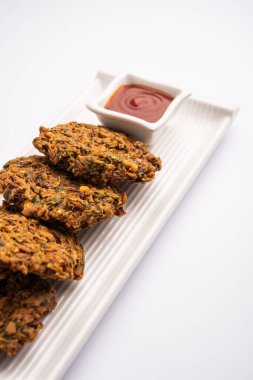 Karışık Dal Vada veya Pakoda, domates ketçaplı veya yeşil turşulu Hint aperatifi.