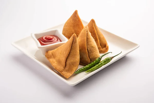 Veg Samosa - is a crispy and spicy Indian triangle shape snack which has crisp outer layer of maida & filling of mashed potato, peas and spices