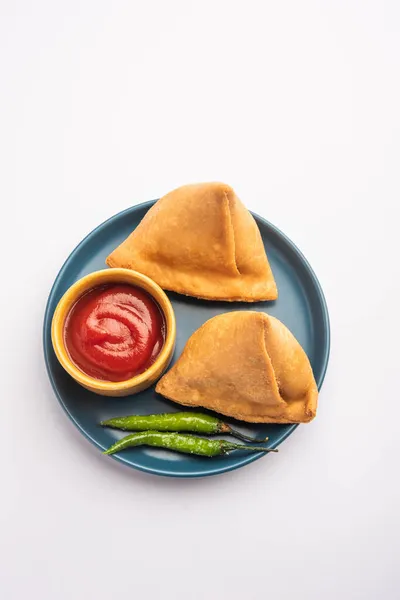 Veg Samosa - is a crispy and spicy Indian triangle shape snack which has crisp outer layer of maida & filling of mashed potato, peas and spices