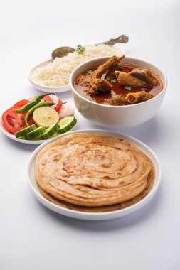 Koyun OR Gosht Masala Ya da Hint kuzusu Rogan Josh biraz baharatlı, Naan, paratha ya da pirinçli Roti ile servis edilir.