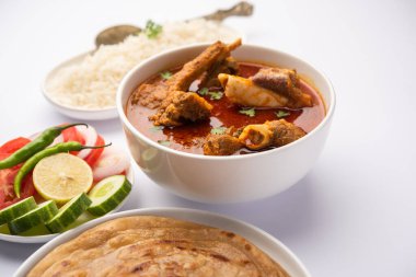 Koyun OR Gosht Masala Ya da Hint kuzusu Rogan Josh biraz baharatlı, Naan, paratha ya da pirinçli Roti ile servis edilir.