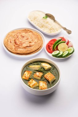Palak paneer veya ıspanak ve süzme peynirli köri pilav ve chapati ile servis edilir.
