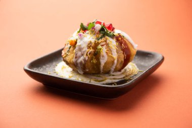 Rajasthani Shahi Raj Kachori, içi patates ve filizle dolu. Bir tabakta lor, acı sos ve sev ile servis edilir.