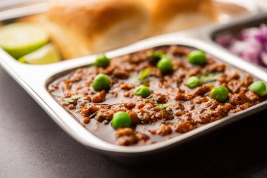 Kheema Pav ya da Hint Baharatlı Kıyma ya da Kuzu eti, yeşil bezelyelerle süslenmiş ekmek ya da kulcha ile servis edilir. Dengesiz bir arka plan. Seçici odak