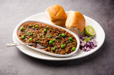 Kheema Pav ya da Hint Baharatlı Kıyma ya da Kuzu eti, yeşil bezelyelerle süslenmiş ekmek ya da kulcha ile servis edilir. Dengesiz bir arka plan. Seçici odak