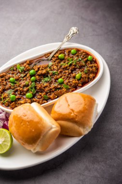 Kheema Pav ya da Hint Baharatlı Kıyma ya da Kuzu eti, yeşil bezelyelerle süslenmiş ekmek ya da kulcha ile servis edilir. Dengesiz bir arka plan. Seçici odak
