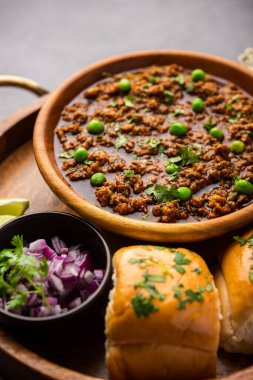 Kheema Pav ya da Hint Baharatlı Kıyma ya da Kuzu eti, yeşil bezelyelerle süslenmiş ekmek ya da kulcha ile servis edilir. Dengesiz bir arka plan. Seçici odak