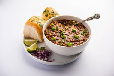 Kheema Pav ya da Hint Baharatlı Kıyma ya da Kuzu eti, yeşil bezelyelerle süslenmiş ekmek ya da kulcha ile servis edilir. Dengesiz bir arka plan. Seçici odak