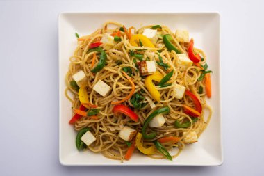 Schezwan veya Szechwan hakka erişteli paneer veya süzme peynir. Bir kasede servis edildi. seçici odak