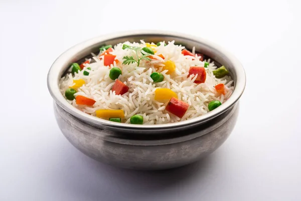 Veg biryani or veg pulav served in a round brass bowl, selective focus