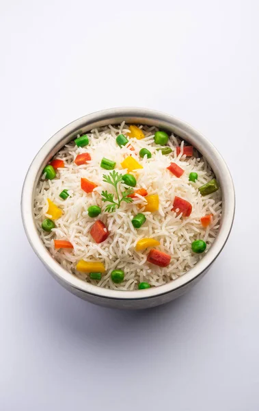 Veg biryani or veg pulav served in a round brass bowl, selective focus