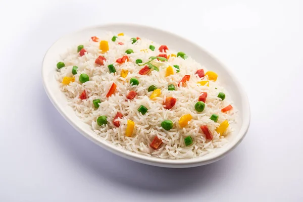 Veg biryani or veg pulav served in a round brass bowl, selective focus