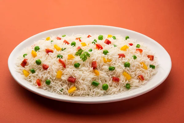 Veg biryani or veg pulav served in a round brass bowl, selective focus