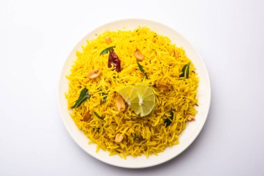 Köri yaprağı, fıstık ve kırmızı biberli limonlu pilav, seramik bir kasede servis ediliyor, seçici bir odak noktası.