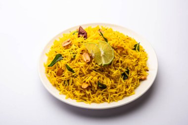 Köri yaprağı, fıstık ve kırmızı biberli limonlu pilav, seramik bir kasede servis ediliyor, seçici bir odak noktası.