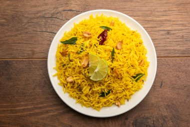 Köri yaprağı, fıstık ve kırmızı biberli limonlu pilav, seramik bir kasede servis ediliyor, seçici bir odak noktası.