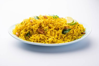 Köri yaprağı, fıstık ve kırmızı biberli limonlu pilav, seramik bir kasede servis ediliyor, seçici bir odak noktası.