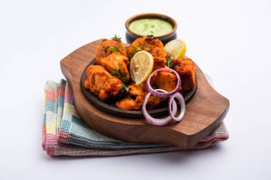 Hint tavuk tikka kebabı, baharat ve yoğurt ile marine edilmiş ve tandırda kızartılmış. Yeşil turşu ve soğanla servis edilir. seçici odak