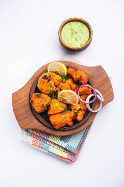 Hint tavuk tikka kebabı, baharat ve yoğurt ile marine edilmiş ve tandırda kızartılmış. Yeşil turşu ve soğanla servis edilir. seçici odak