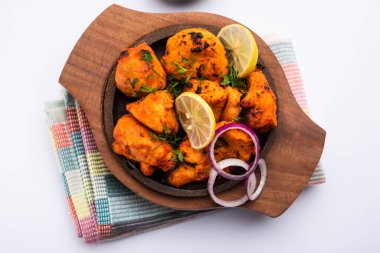 Hint tavuk tikka kebabı, baharat ve yoğurt ile marine edilmiş ve tandırda kızartılmış. Yeşil turşu ve soğanla servis edilir. seçici odak