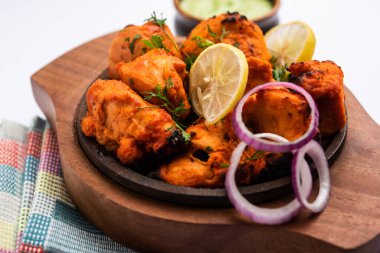 Indian chicken tikka kebabs, marinated in spices and yogurt and roasted in tandoor. served with green chutney and onion. selective focus clipart