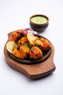 Hint tavuk tikka kebabı, baharat ve yoğurt ile marine edilmiş ve tandırda kızartılmış. Yeşil turşu ve soğanla servis edilir. seçici odak