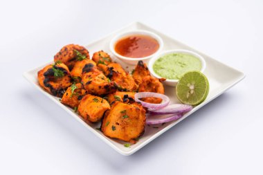 Hint tavuk tikka kebabı, baharat ve yoğurt ile marine edilmiş ve tandırda kızartılmış. Yeşil turşu ve soğanla servis edilir. seçici odak