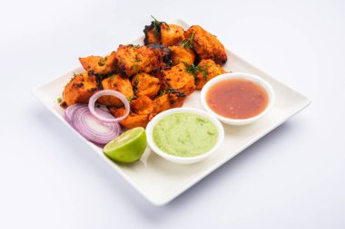 Hint tavuk tikka kebabı, baharat ve yoğurt ile marine edilmiş ve tandırda kızartılmış. Yeşil turşu ve soğanla servis edilir. seçici odak