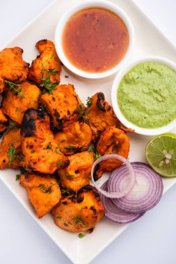 Hint tavuk tikka kebabı, baharat ve yoğurt ile marine edilmiş ve tandırda kızartılmış. Yeşil turşu ve soğanla servis edilir. seçici odak
