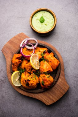 Hint tavuk tikka kebabı, baharat ve yoğurt ile marine edilmiş ve tandırda kızartılmış. Yeşil turşu ve soğanla servis edilir. seçici odak