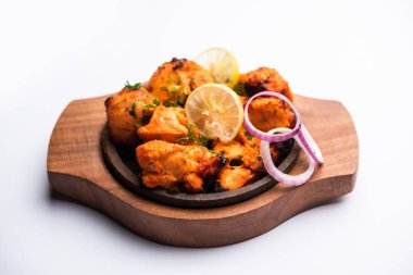 Hint tavuk tikka kebabı, baharat ve yoğurt ile marine edilmiş ve tandırda kızartılmış. Yeşil turşu ve soğanla servis edilir. seçici odak