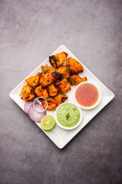 Hint tavuk tikka kebabı, baharat ve yoğurt ile marine edilmiş ve tandırda kızartılmış. Yeşil turşu ve soğanla servis edilir. seçici odak