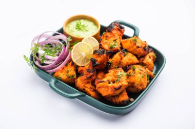 Hint tavuk tikka kebabı, baharat ve yoğurt ile marine edilmiş ve tandırda kızartılmış. Yeşil turşu ve soğanla servis edilir. seçici odak