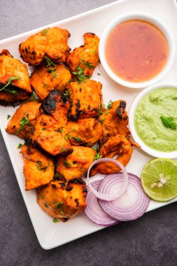 Hint tavuk tikka kebabı, baharat ve yoğurt ile marine edilmiş ve tandırda kızartılmış. Yeşil turşu ve soğanla servis edilir. seçici odak