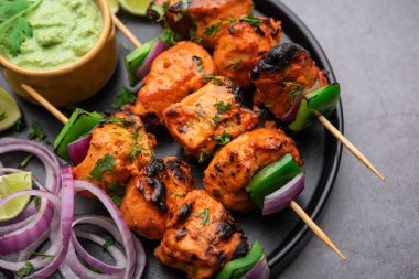 Hint tavuk tikka kebabı, baharat ve yoğurt ile marine edilmiş ve tandırda kızartılmış. Yeşil turşu ve soğanla servis edilir. seçici odak