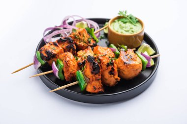 Hint tavuk tikka kebabı, baharat ve yoğurt ile marine edilmiş ve tandırda kızartılmış. Yeşil turşu ve soğanla servis edilir. seçici odak