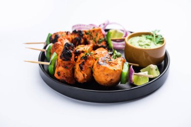 Hint tavuk tikka kebabı, baharat ve yoğurt ile marine edilmiş ve tandırda kızartılmış. Yeşil turşu ve soğanla servis edilir. seçici odak