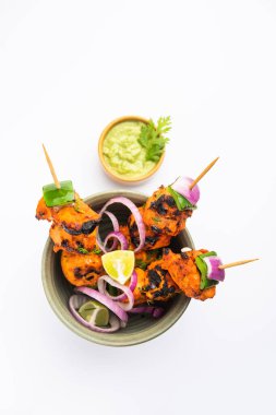 Hint tavuk tikka kebabı, baharat ve yoğurt ile marine edilmiş ve tandırda kızartılmış. Yeşil turşu ve soğanla servis edilir. seçici odak