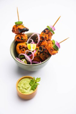 Hint tavuk tikka kebabı, baharat ve yoğurt ile marine edilmiş ve tandırda kızartılmış. Yeşil turşu ve soğanla servis edilir. seçici odak