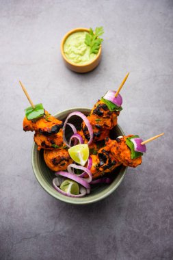 Hint tavuk tikka kebabı, baharat ve yoğurt ile marine edilmiş ve tandırda kızartılmış. Yeşil turşu ve soğanla servis edilir. seçici odak