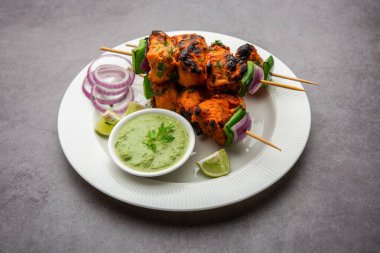 Hint tavuk tikka kebabı, baharat ve yoğurt ile marine edilmiş ve tandırda kızartılmış. Yeşil turşu ve soğanla servis edilir. seçici odak
