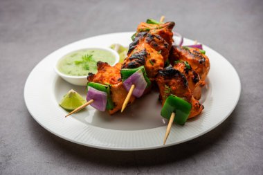 Hint tavuk tikka kebabı, baharat ve yoğurt ile marine edilmiş ve tandırda kızartılmış. Yeşil turşu ve soğanla servis edilir. seçici odak