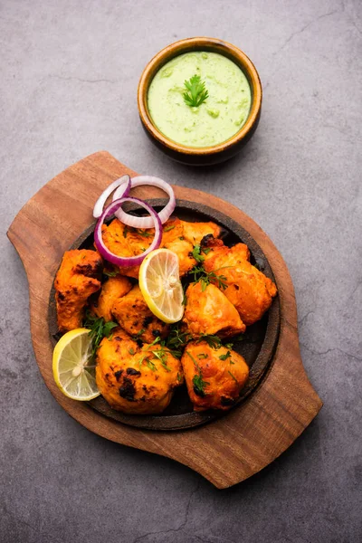 Hint tavuk tikka kebabı, baharat ve yoğurt ile marine edilmiş ve tandırda kızartılmış. Yeşil turşu ve soğanla servis edilir. seçici odak