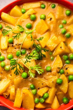 Aloo mırıldanan Hint alt kıtasında baharatlı kremalı domates sosunda patates ve bezelyeden yapılan bir Punjab yemeğidir.