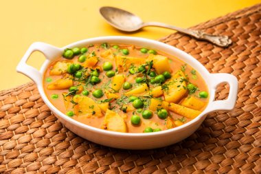 Aloo mırıldanan Hint alt kıtasında baharatlı kremalı domates sosunda patates ve bezelyeden yapılan bir Punjab yemeğidir.