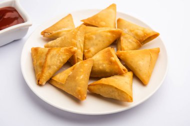 cocktail mini triangle samosa made using patti or strip, popular home made snack from India clipart