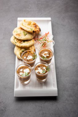 Dal Makhani veya dal Makhni Shots with Naan böbrek fasülyesi, tereyağı ve krema ve sarımsaklı naan veya Hint ekmeği veya roti ile servis edilir.