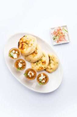 Dal Makhani veya dal Makhni Shots with Naan böbrek fasülyesi, tereyağı ve krema ve sarımsaklı naan veya Hint ekmeği veya roti ile servis edilir.