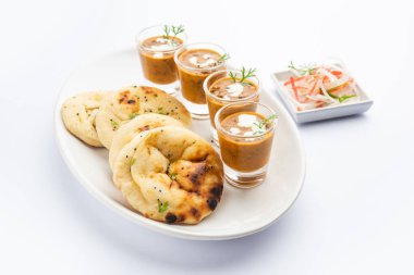Dal Makhani veya dal Makhni Shots with Naan böbrek fasülyesi, tereyağı ve krema ve sarımsaklı naan veya Hint ekmeği veya roti ile servis edilir.