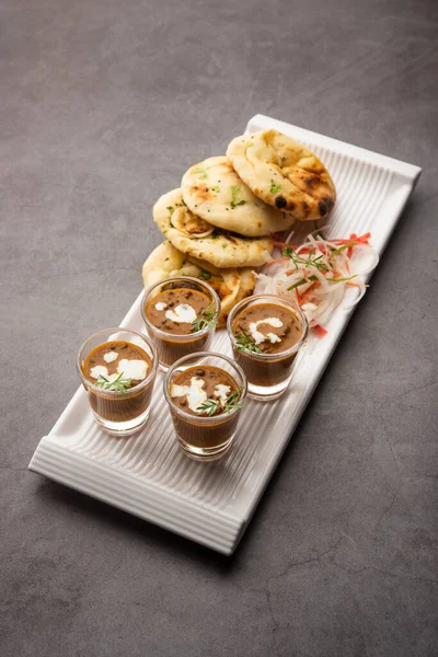 Dal Makhani veya dal Makhni Shots with Naan böbrek fasülyesi, tereyağı ve krema ve sarımsaklı naan veya Hint ekmeği veya roti ile servis edilir.